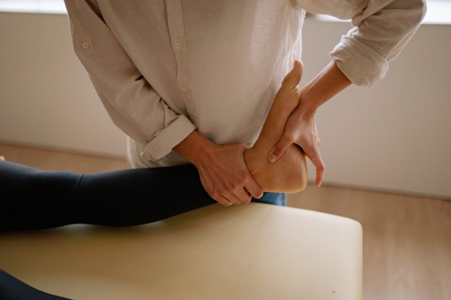 A close up of a persons leg as they appear to be lying down with a practitioner pressing deeply into their foot